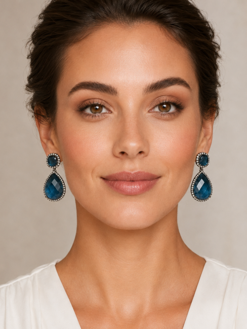 Woman wearing blue crystal teardrop statement earrings